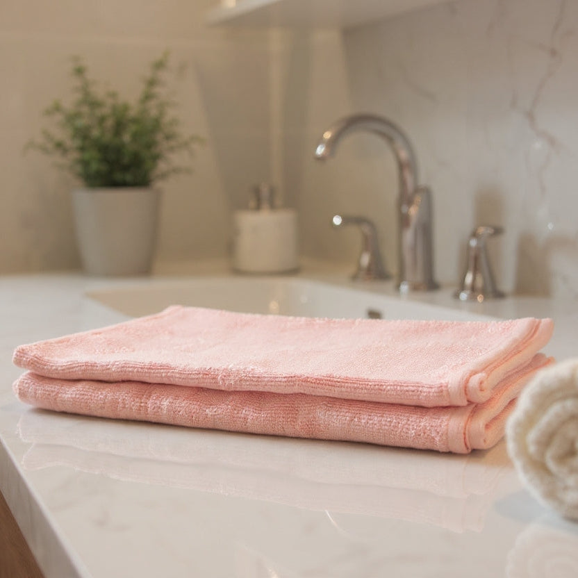 Pink towel on a bathroom counter with a neutral background